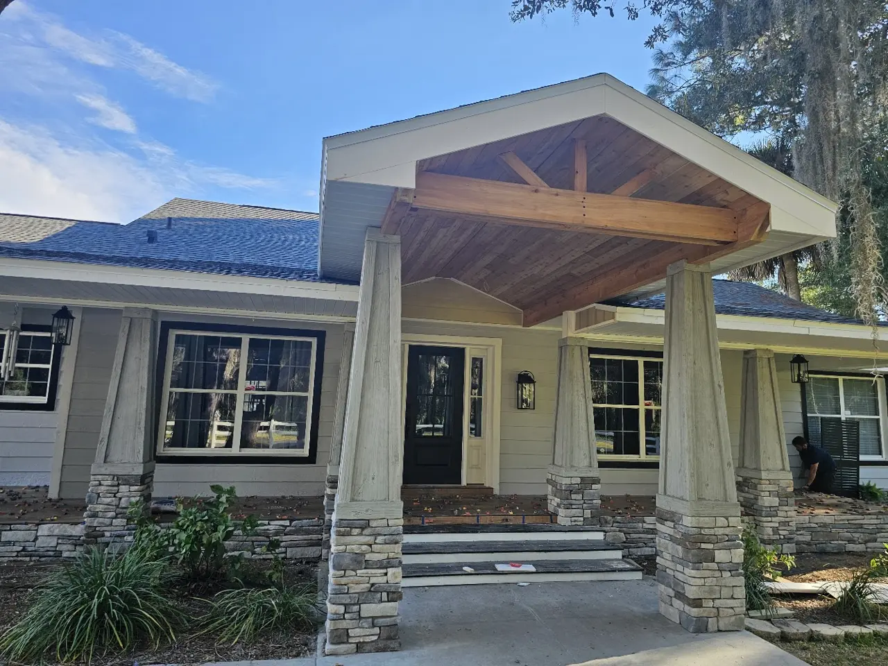 Wide view of a covered entry project with timber ceiling and stone columns